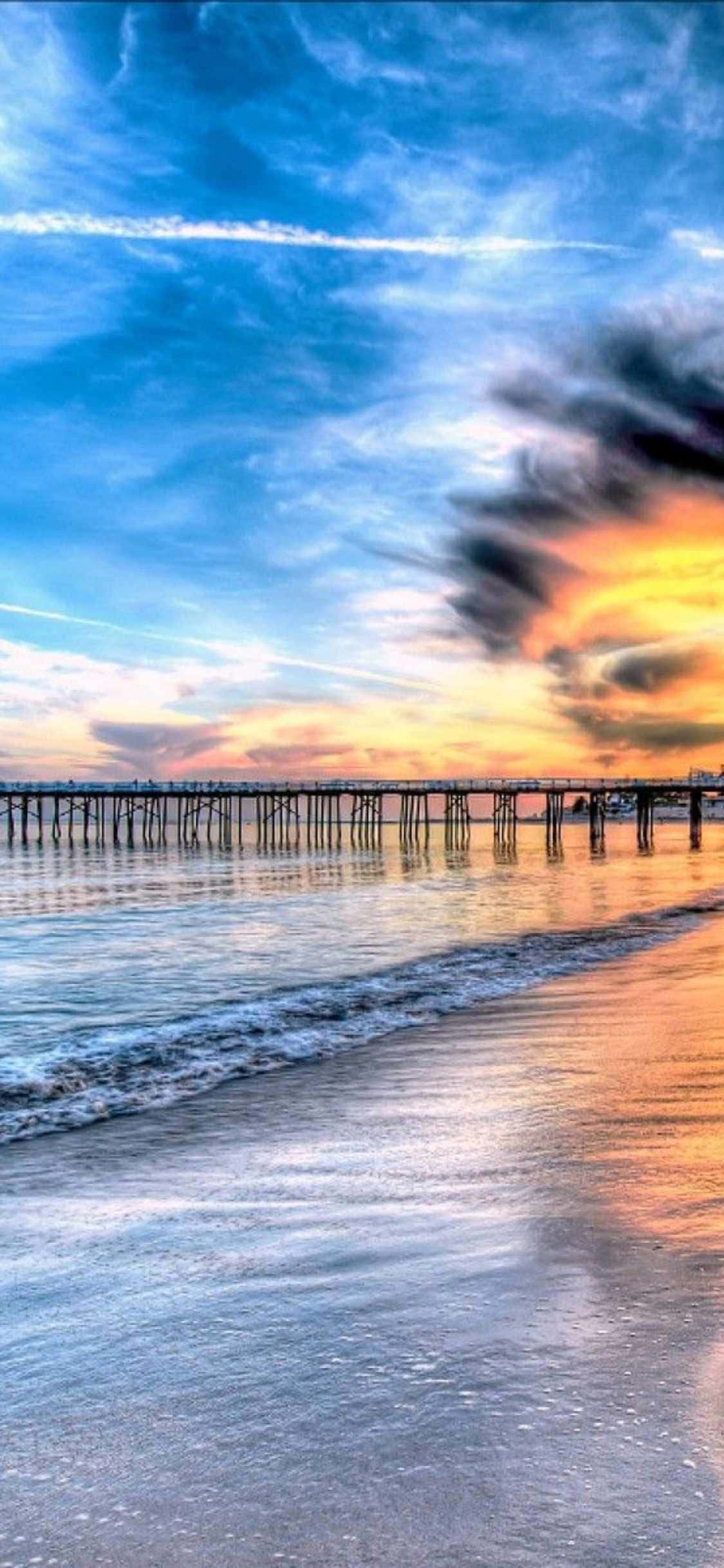 a pier with a sunset over the ocean Duvar Kağıdı