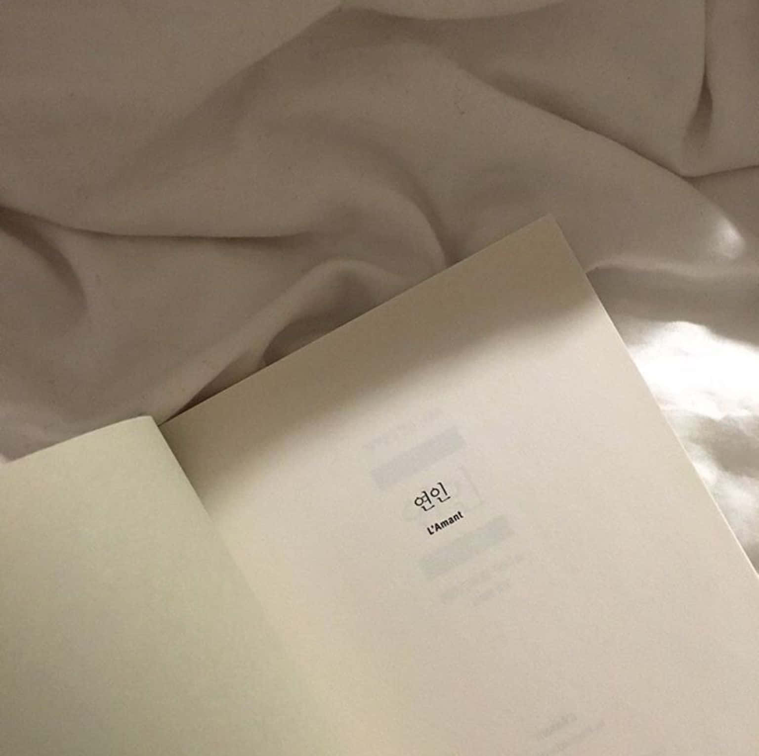 beyaz kapaklı bir kitap yatakta Duvar Kağıdı