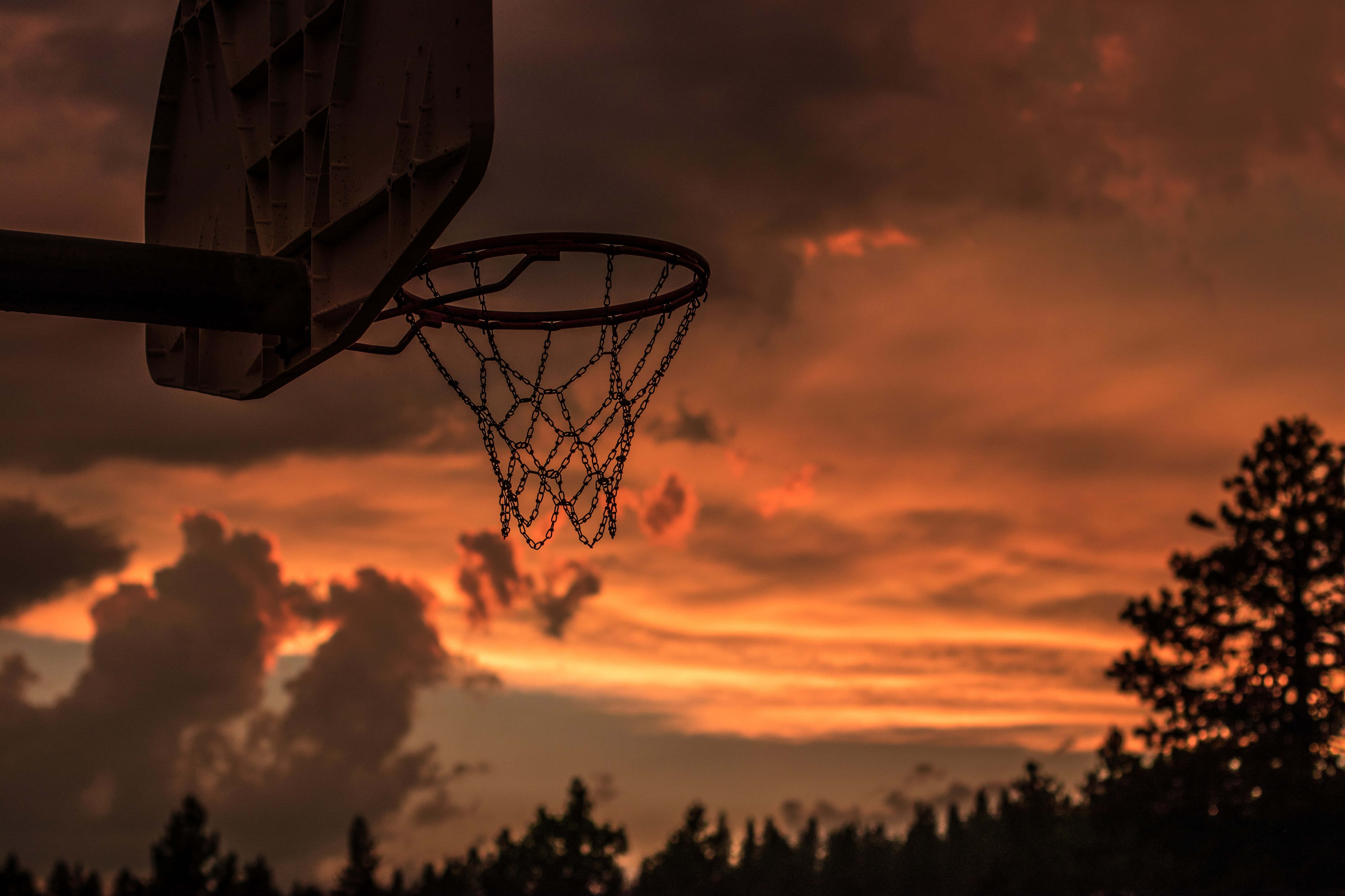 Bir basketbol potası ve arkasında gün batımı gökyüzü Duvar Kağıdı