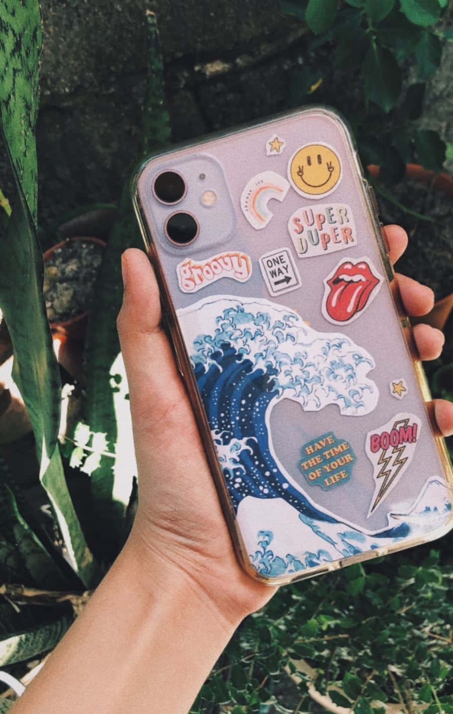 Bir kişi çıkartmalı telefon kılıfı tutuyor Duvar Kağıdı