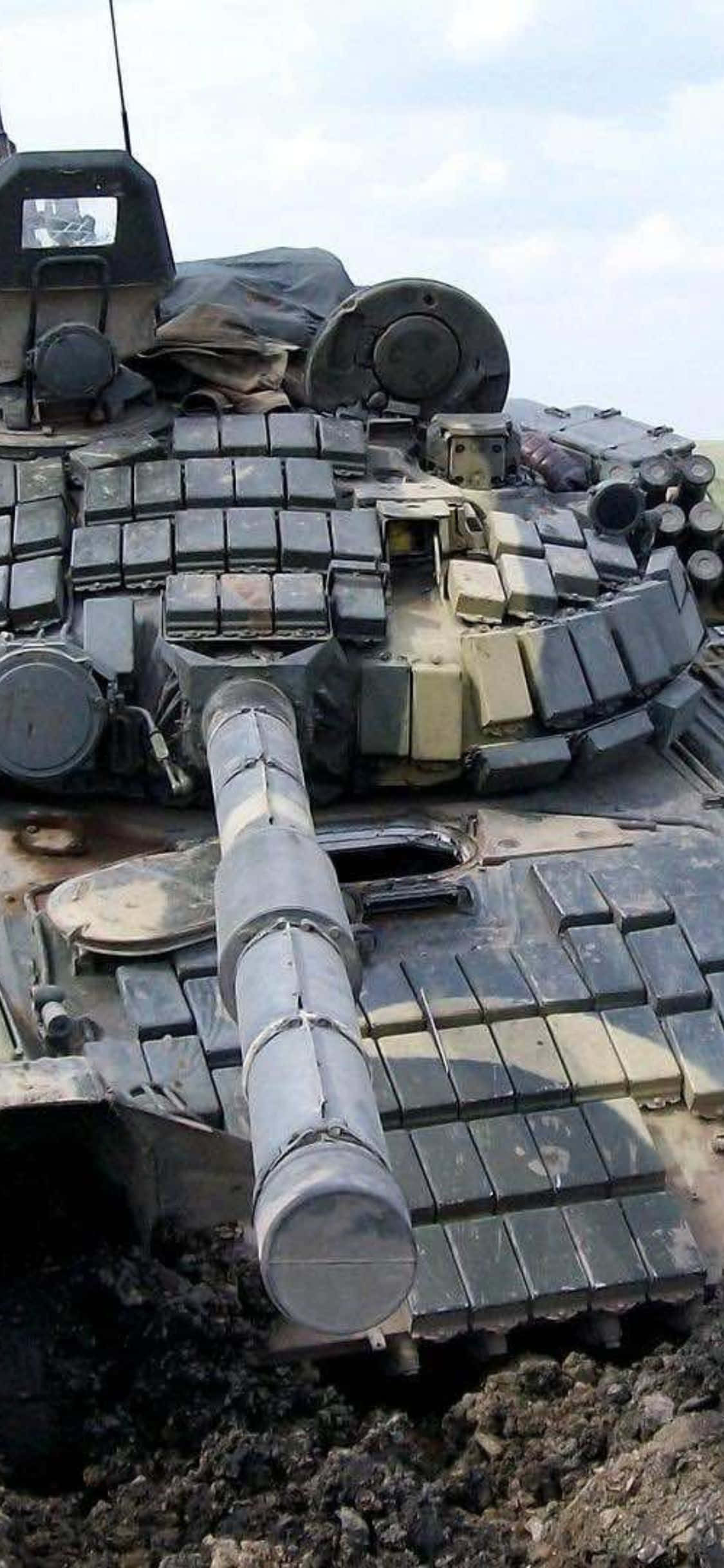 bir tank, çok sayıda ekipman parçasıyla birlikte toprağın içinde oturuyor Duvar Kağıdı