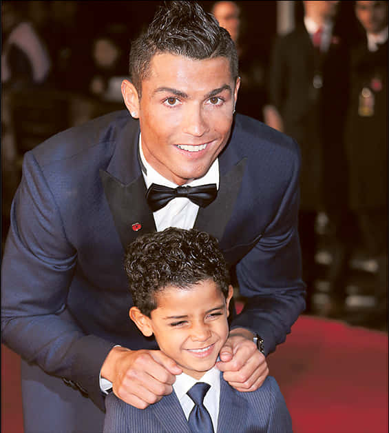 Cristiano Ronaldo Etkinlikte Çocukla Gülümsüyor Duvar Kağıdı
