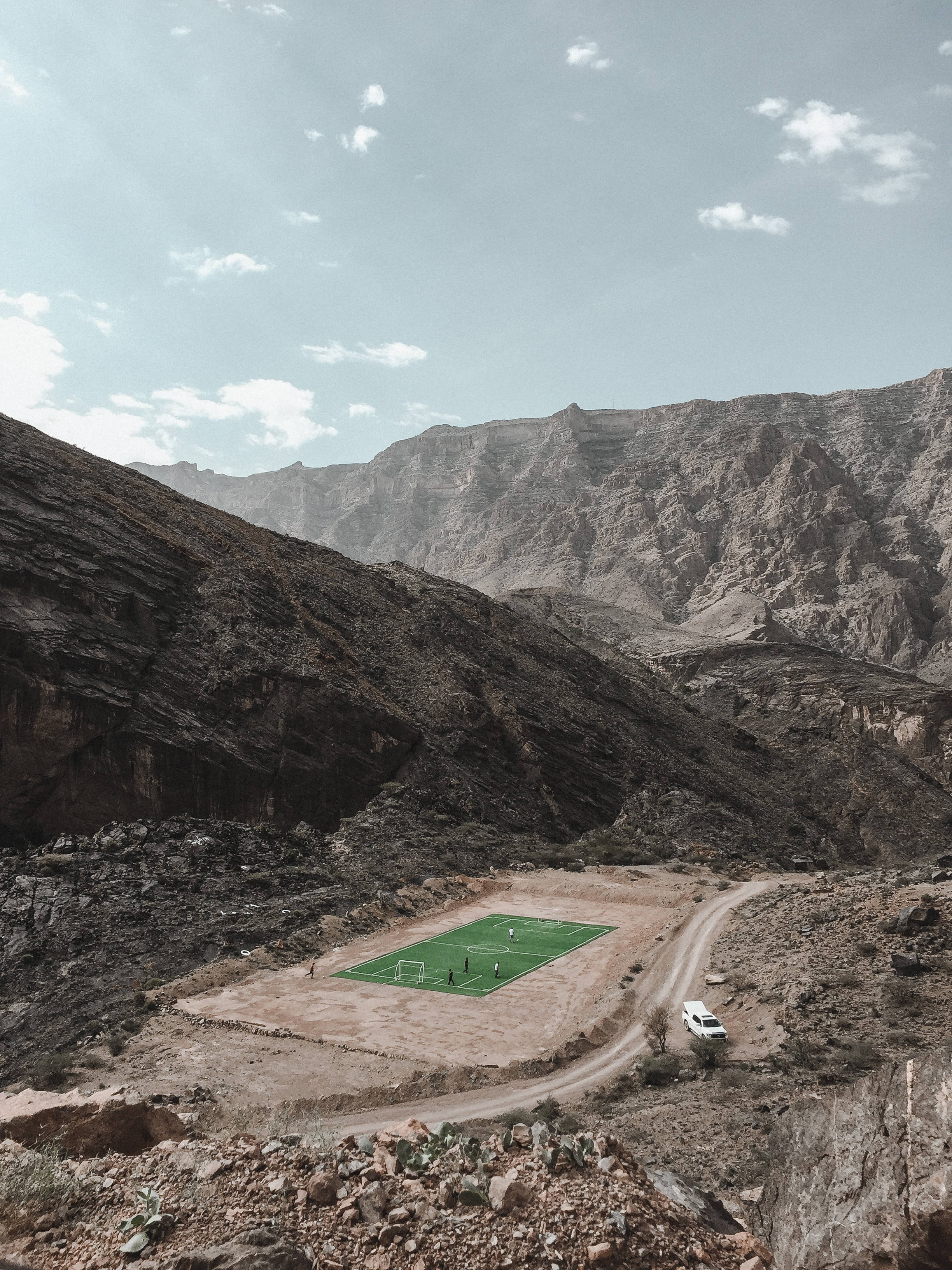 Dağ silsilesinin zirvesinden aşağıdaki futbol stadyumuna bir bakış Duvar Kağıdı