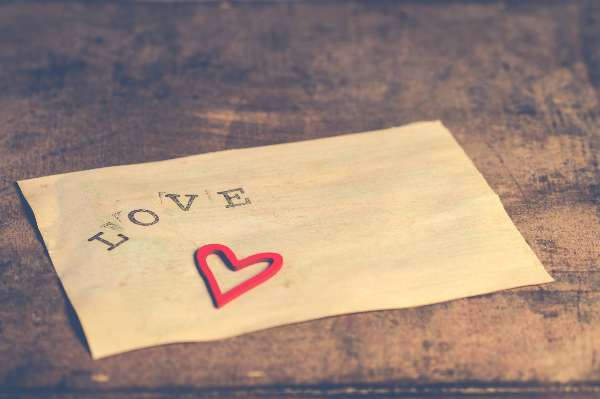 Üzerinde "Love" yazılı mektup ve Sevgililer Günü'nde aşk itirafı için sevimli küçük kırmızı kalp çıkartması.