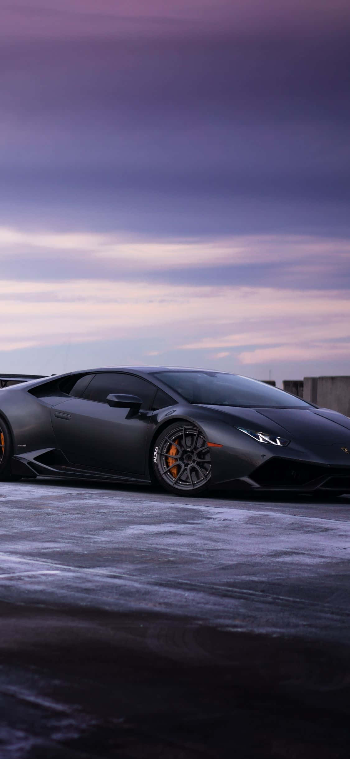 karlı bir yolda park etmiş siyah bir lamborghini Duvar Kağıdı