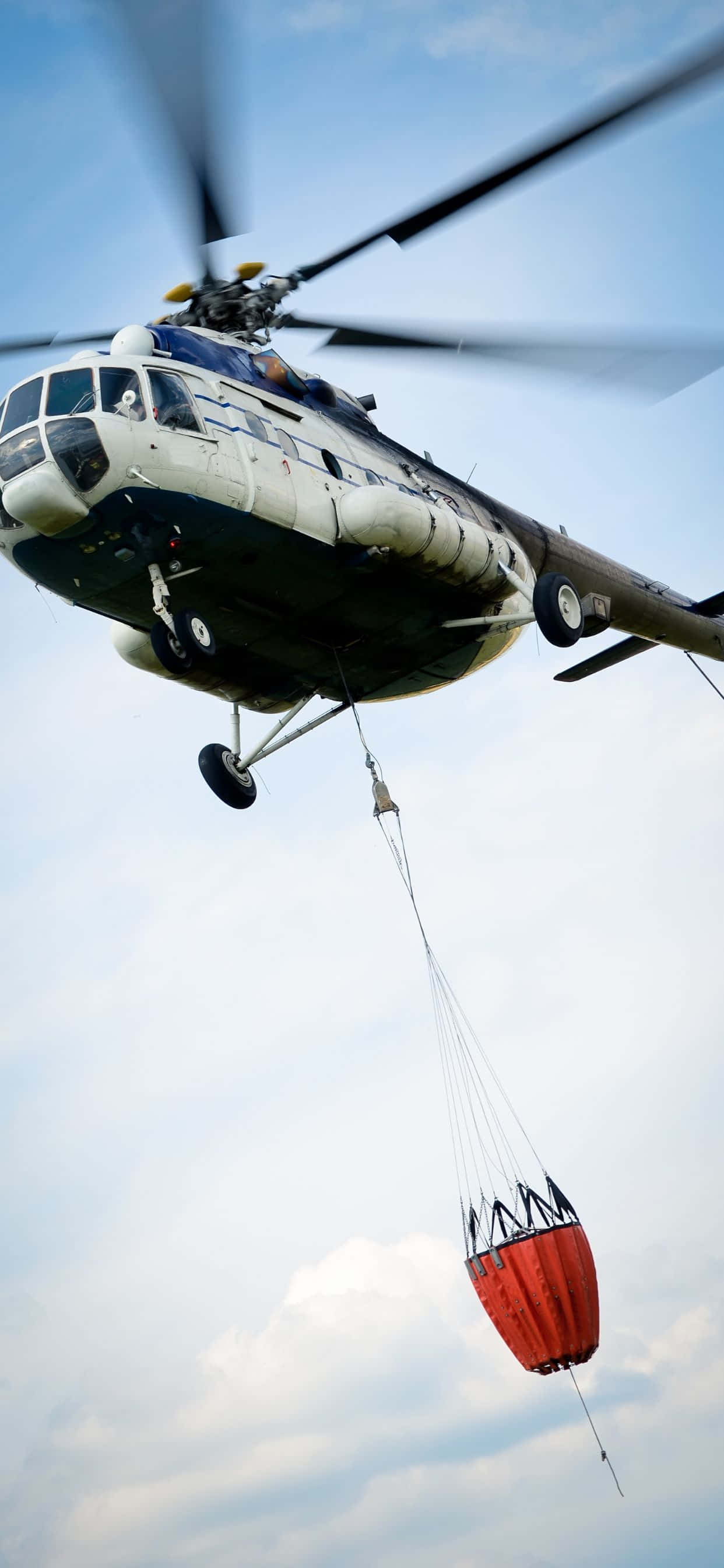 kırmızı bir çanta bağlı olan bir helikopter uçuyor Duvar Kağıdı