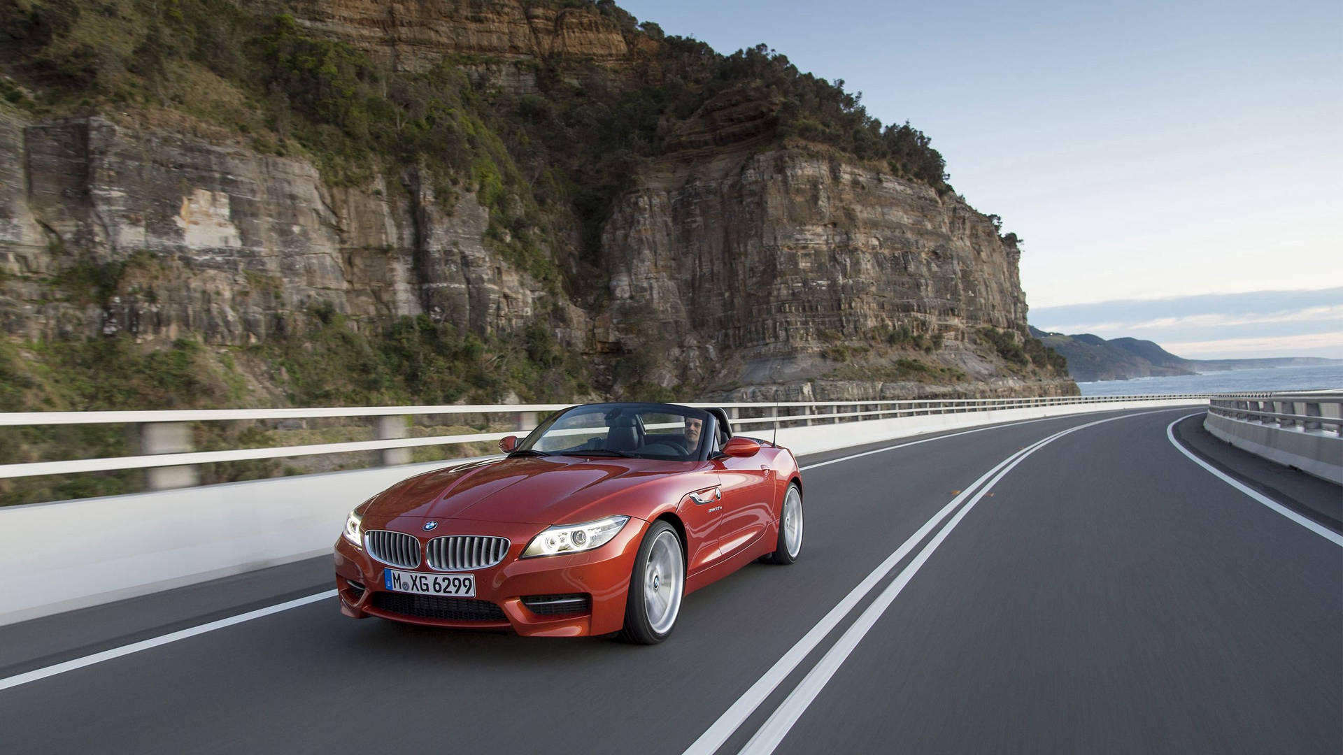 Dağ yanındaki yolda turuncu BMW Z4 otomobil duvar kağıdı