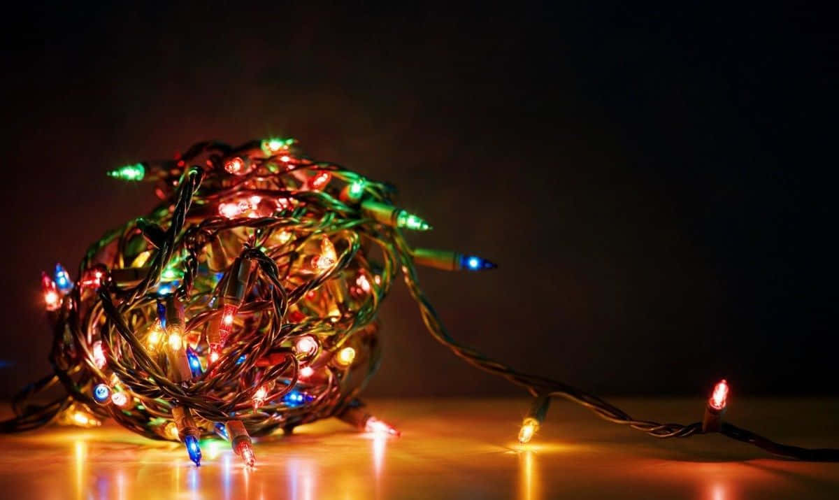 Kış temalı bir ağacın etrafına sarılmış büyülü Noel ışıkları Duvar Kağıdı
