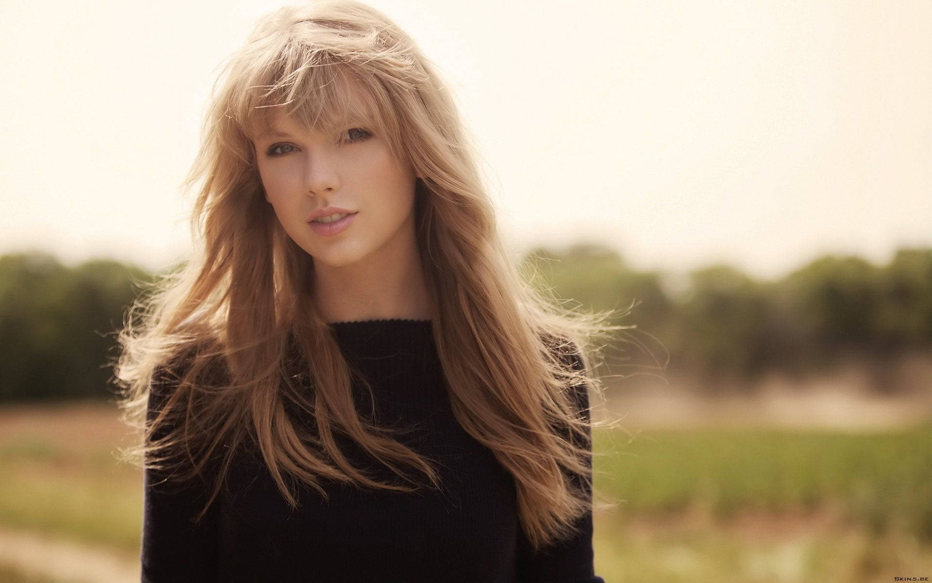 Taylor Swift müzik videosu, düz saçlı ve siyah tişörtlü.