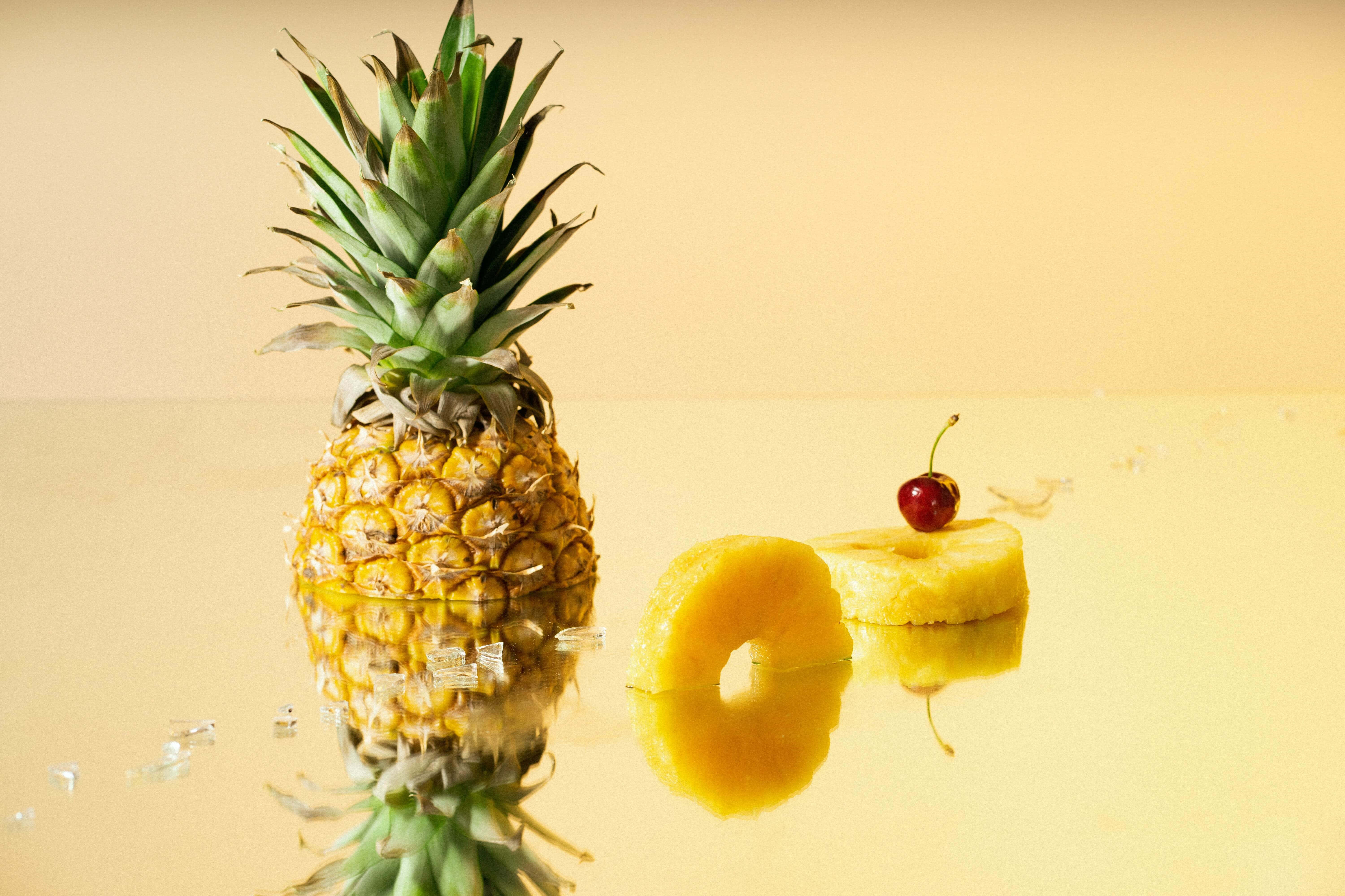 Taze ve sulu bir ananas, pitoresk bir gün batımının ön planında duruyor. Duvar Kağıdı
