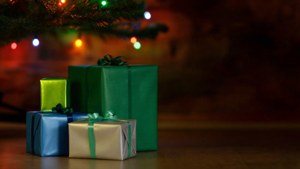 Renkli hediyeler, ışıldayan ışıklarla bir Noel ağacının altında istiflenmiş. — Noel Hediyeleri Duvar Kağıdı