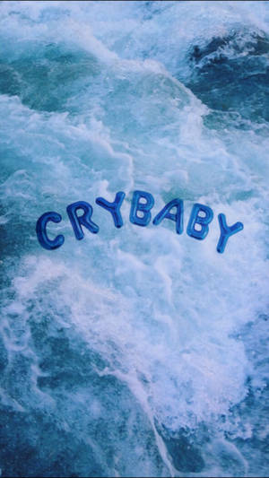 Mavi okyanus veya deniz üzerinde süzülen büyük balon harflerle 'Crybaby' yazısını gösteren serin mavi estetik duvar kağıdı.