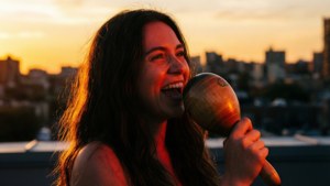 Vivo, gün batımında bir çatı katında elinde marakasla içten bir şarkı söylüyor.