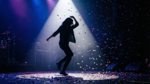 Sahne üzerinde konfeti eşliğinde dans eden bir dansçının dramatik silüeti. — Müzik estetiği Duvar Kağıdı