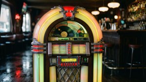 Loş bir retro barda neon ışıklı bir jukebox.
