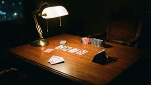 Bir masa lambasıyla aydınlatılan, noir esintili bir solitaire oyunu — 1366x768 Duvar Kağıdı