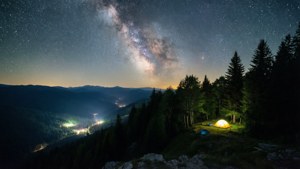 Kamp alanı ışıltısıyla dağ sırtından yıldızlı gece manzarası. — ROG Ally Duvar Kağıdı
